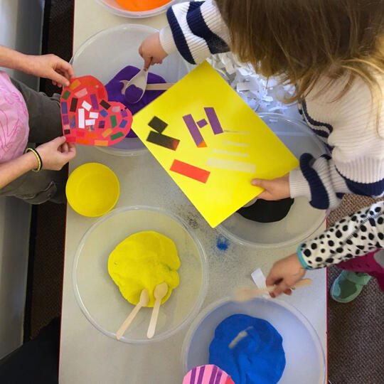 people participating in session with bowls of colourful sand